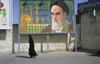 Iran - Qom: woman under billboard with Ayatollah Ruhollah Khomeini - photo by W.Allgower