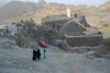 Yemen - Hajja governorate - two women in black and a girl blue  near an old water reservoir - photo by E.Andersen